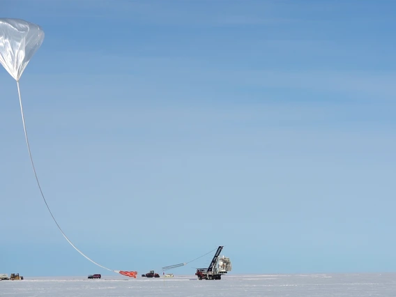 Tethered by a long cable, the high altitude balloon carrying the GUSTO telescope is being launched from McMurdo Research Station in Antarctica.