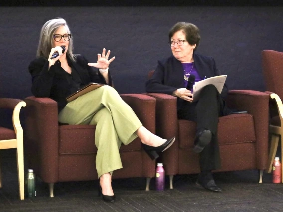 katie hobbs and sharon megdal sitting on chairs on a stage and talking