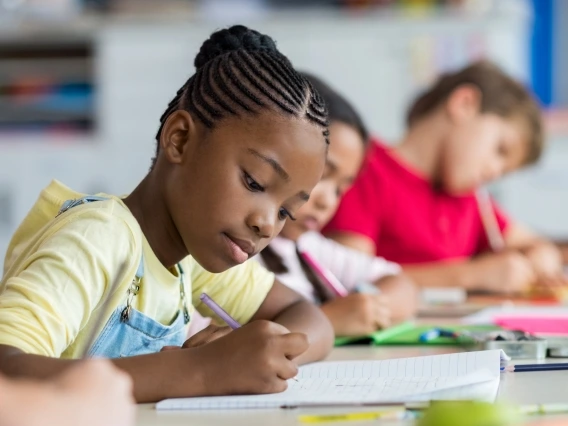 student sitting at a table and writing