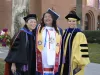 Angela Acuna, Sharon Hom and Timian Godfrey smiling and posing for a photo in caps and gowns